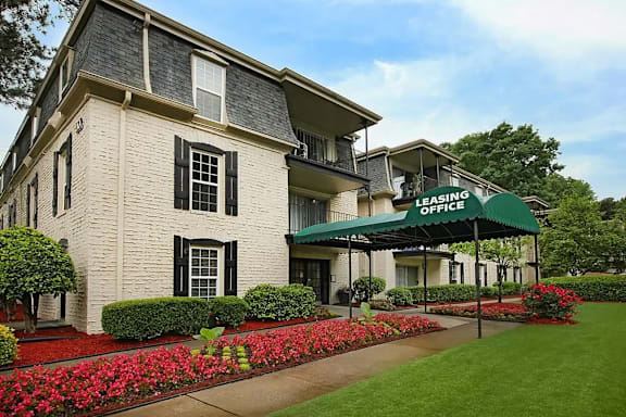 A two-story apartment building with a car parked in front.