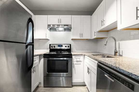 A modern kitchen with stainless steel appliances and white cabinets.