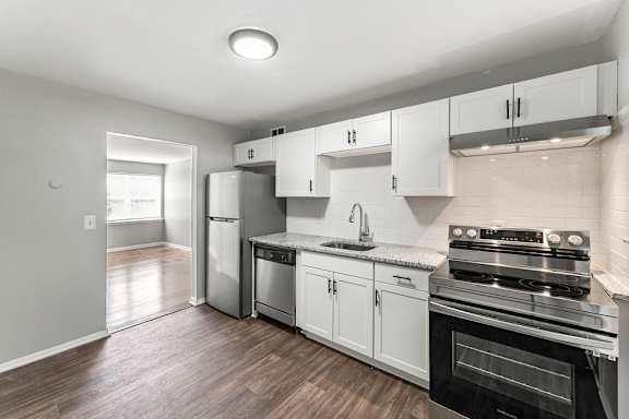 A kitchen with white cabinets and a black oven.