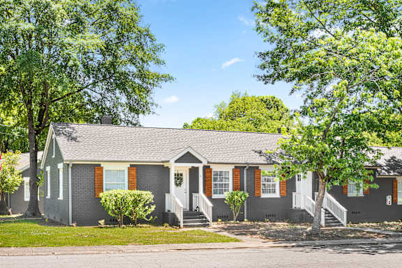 A grey house with red shutters and a white door at Balfour Marietta Apartments, Georgia