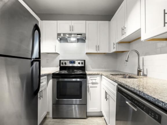 a kitchen with stainless steel appliances and white cabinets at Georgian Oaks Apartments l &amp; ll* Apartments, Smyrna , GA, 30080