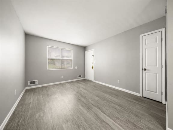 an empty bedroom with a white door and wood floors at Georgian Oaks Apartments l &amp; ll* Apartments, Smyrna , Georgia
