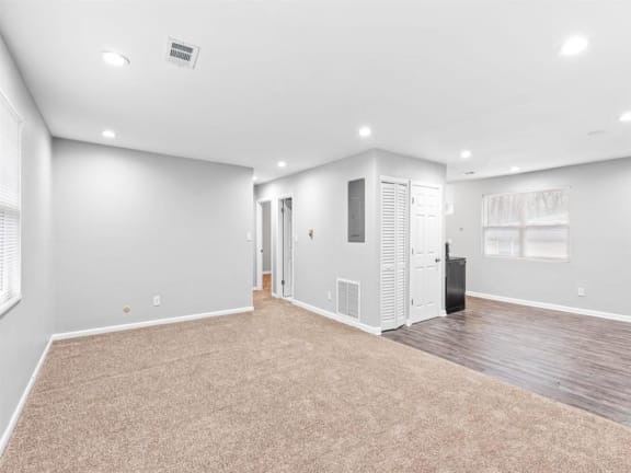 the living room is empty of furniture and has white walls and a carpet at Georgian Oaks Apartments l &amp; ll* Apartments, Smyrna , GA