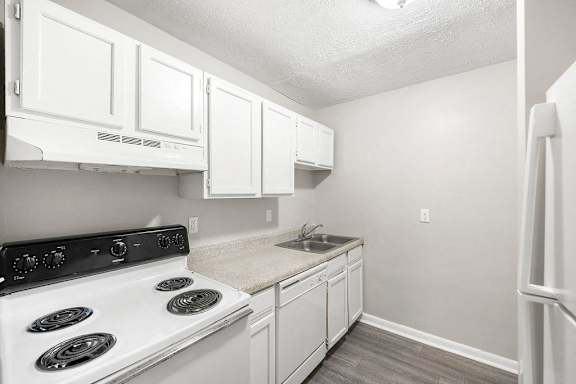 A kitchen with white cabinets and a black stove top.