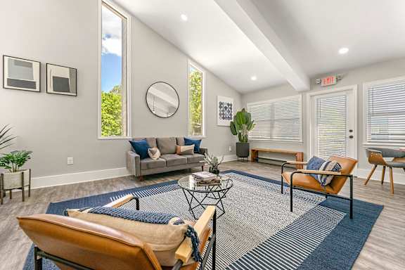 A living room with a grey sofa, a coffee table, a chair and a mirror.