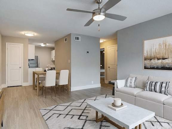 A modern living room with a dining area and a white sofa.
