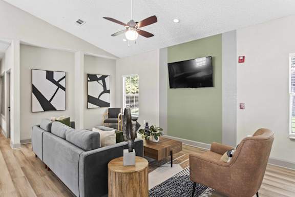 A living room with a grey couch, a brown chair, and a wooden coffee table.