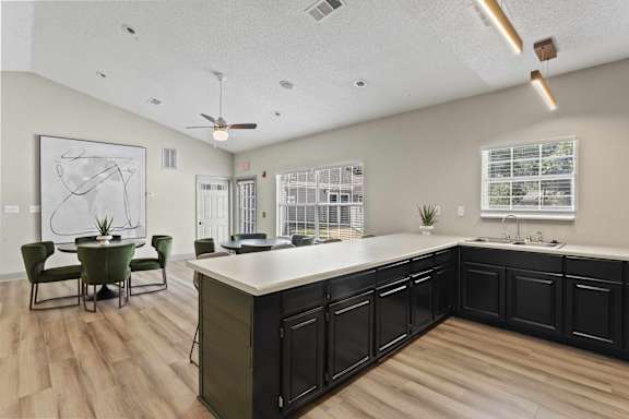 A kitchen with a large island and a dining table with chairs.