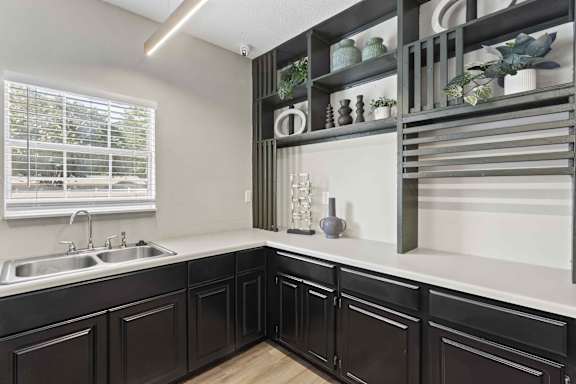 A kitchen with black cabinets and a white countertop.