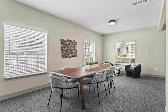 A dining room with a wooden table and chairs.