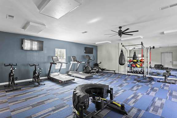 A gym with a variety of equipment including treadmills, exercise bikes, and weight machines.