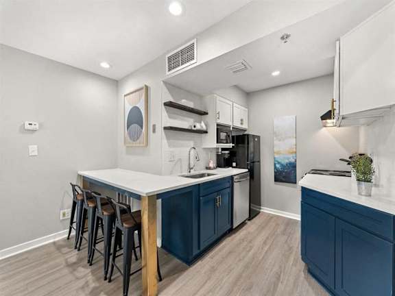 A kitchen with a white countertop and blue cabinets.