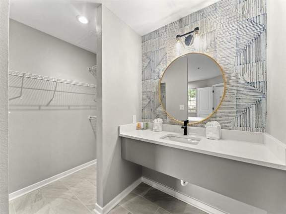 A bathroom with a round mirror and a sink.