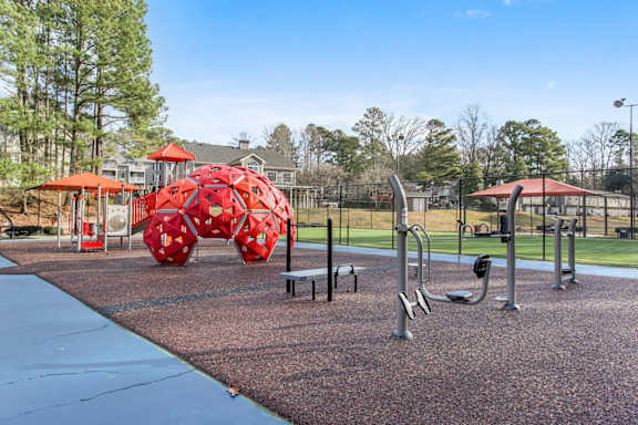 A playground with red and grey equipment.