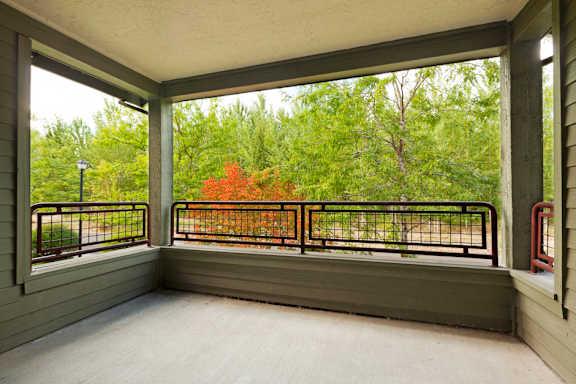 the porch has a view of the woods and a large window