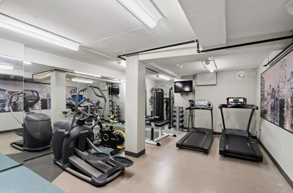 A gym with treadmills, elliptical machines, and other exercise equipment.
