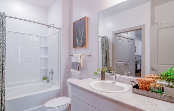 a bathroom with a sink and a tub and a mirror at Carmel Vista, McDonough, GA