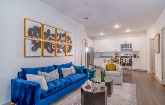 a living room with a blue couch and a kitchen in the background at Carmel Vista, McDonough, 30253