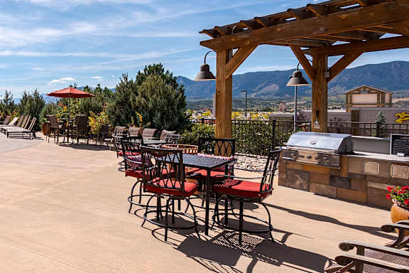 A patio with tables and chairs and a mountain in the background at Vistas at Jackson Creek, Colorado