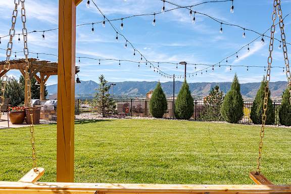 A swing set with a view of the mountains in the background at Vistas at Jackson Creek, Monument, CO, 80132