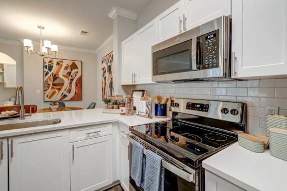A kitchen with white cabinets and a black stove top oven.