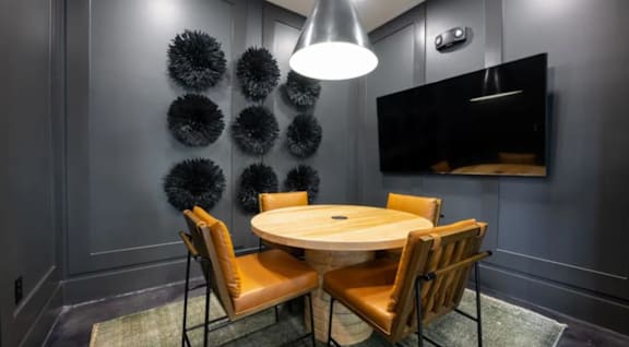 A modern dining room with a round table and chairs.