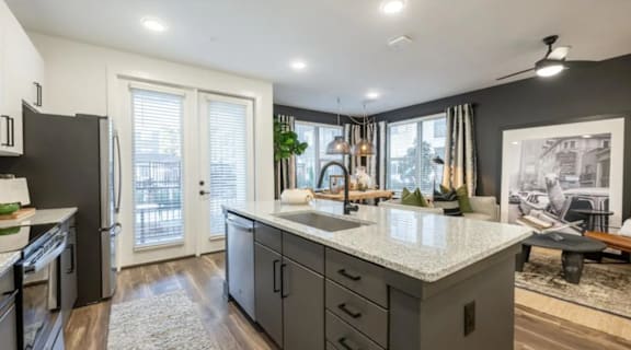 A modern kitchen with a large island and stainless steel appliances.