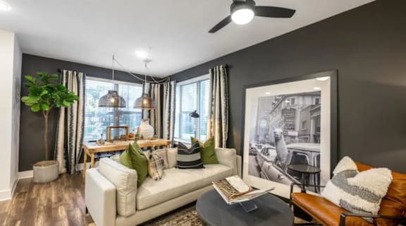 A living room with a white couch, a coffee table, and a large picture on the wall.
