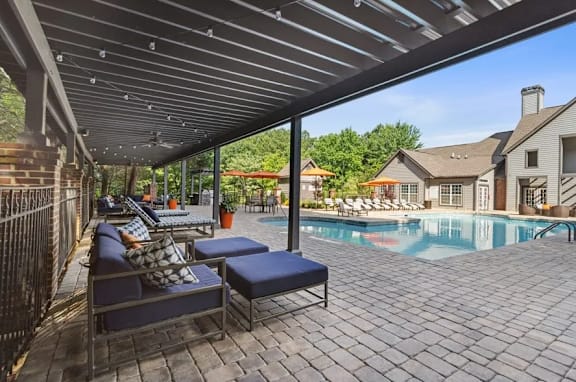 A patio with a pool and a covered seating area at The Hartley at Sweetwater Creek, GA 30096