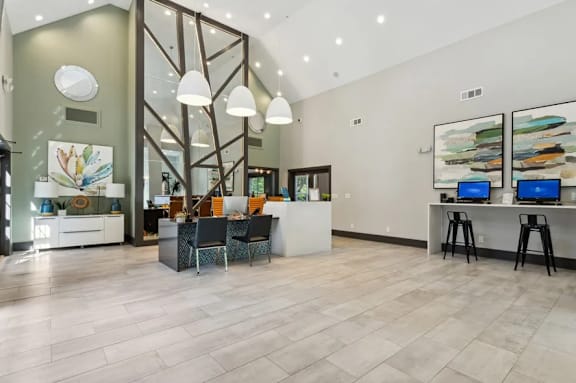Business center area with a white counter and chairs with two computers at The Hartley at Sweetwater Creek, Duluth, 30096