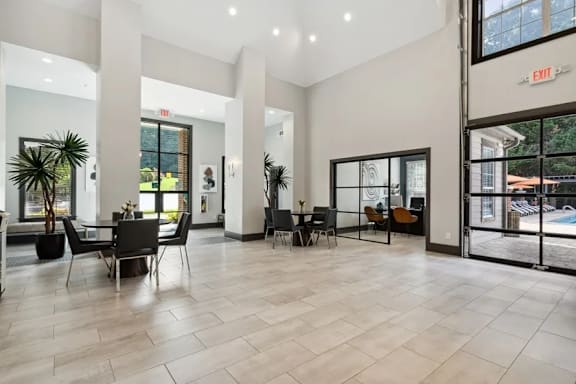 A spacious lobby with a pool visible through the glass doors at The Hartley at Sweetwater Creek, Duluth, GA, 30096