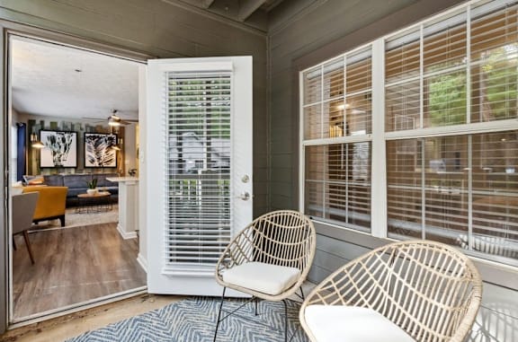 Oversized patio with a white door and two wicker chairs at The Hartley at Sweetwater Creek, Duluth, Georgia