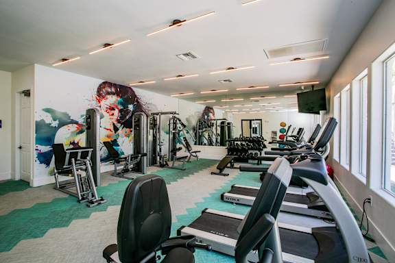 A gym with treadmills, weights, and exercise equipment. at Octave Apartments, Las Vegas, 89123