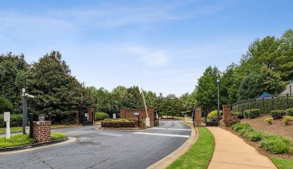 A road with a sign and a fence on the right side.