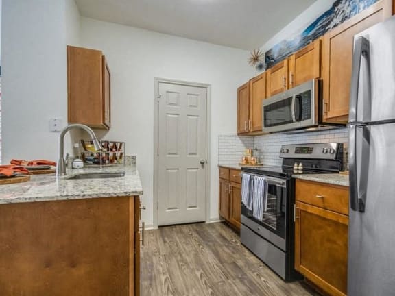a kitchen with wooden cabinets and stainless steel appliances