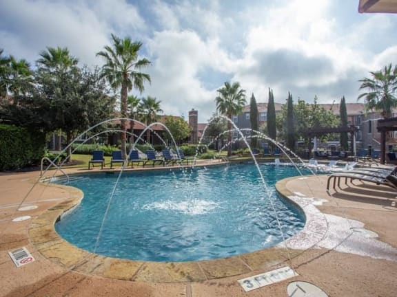 a large swimming pool with water sprinklers