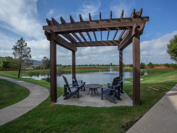 a patio with a table and chairs next to a lake