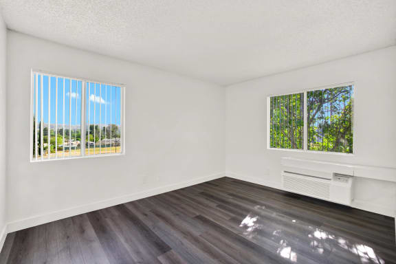 an empty living room with wood flooring and a window at Monterra Ridge Apartments, Canyon Country