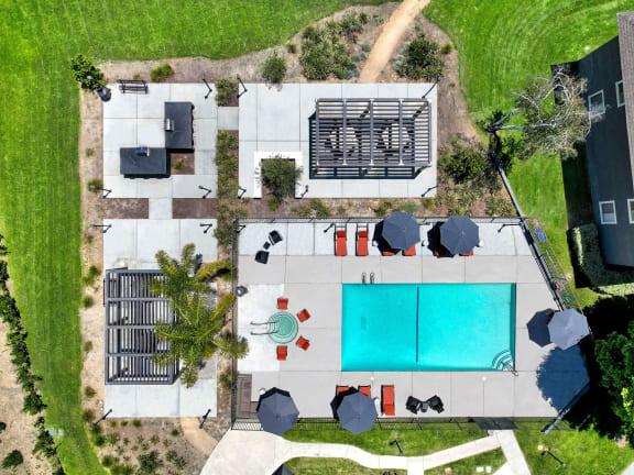 Top view of the pool and yard of a house with a blue pool at Monterra Ridge Apartments, Canyon Country
