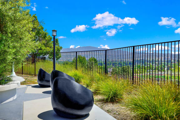 a group of chairs sitting in front of a fence at Monterra Ridge Apartments,California
