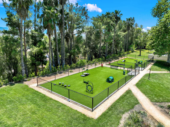 a park with a tennis court and a fence at Monterra Ridge Apartments,California
