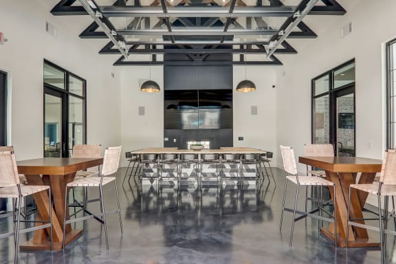 a large room with tables and chairs and a kitchen in the background