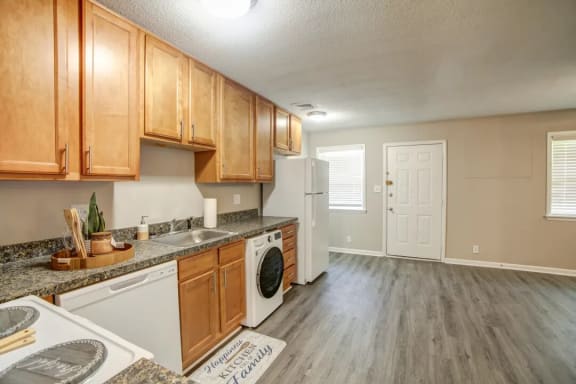 a kitchen with wooden cabinets and a washer and dryer