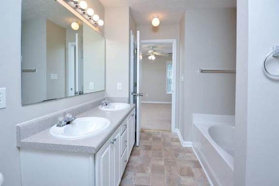 A bathroom with a white sink and a white tub.