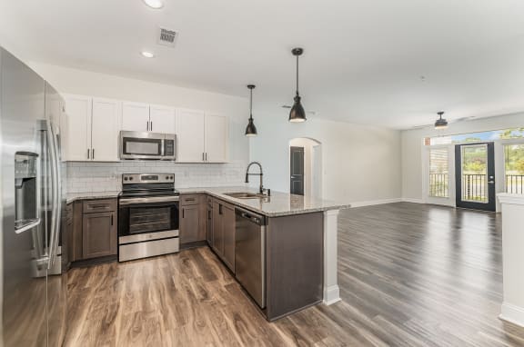 a kitchen and living room with hardwood floors and white cabinets