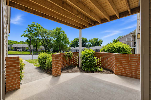 A patio with a wooden roof and brick pillars.