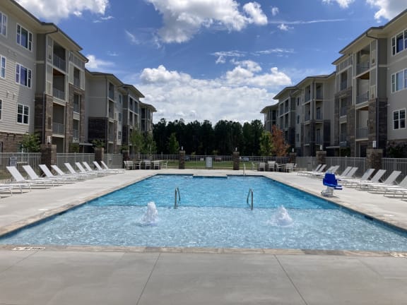 an apartment pool with water jets in front of an apartment building