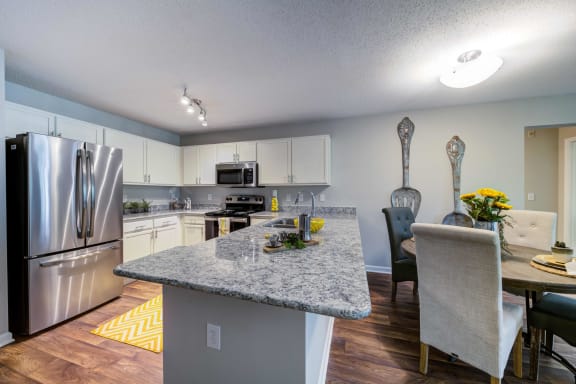 Kitchen with double door stainless steel refrigerator, range, and microwave.