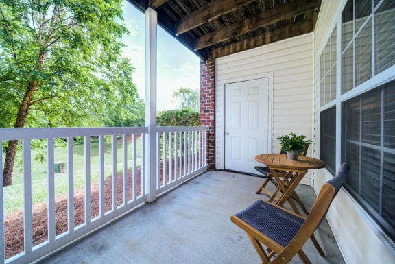 Lovely covered porch area with a natural view.
