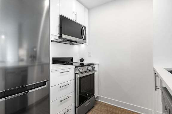 A modern kitchen with stainless steel appliances and white cabinets.